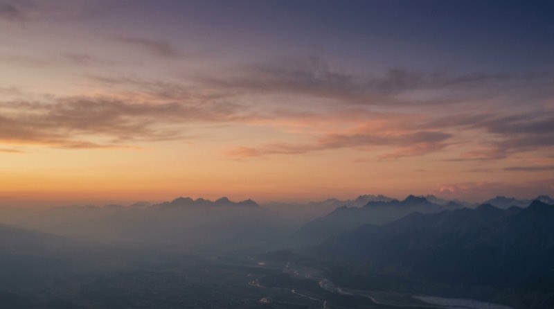 Gestaffelte Bergketten über dem Talnebel bei Sonnenuntergang