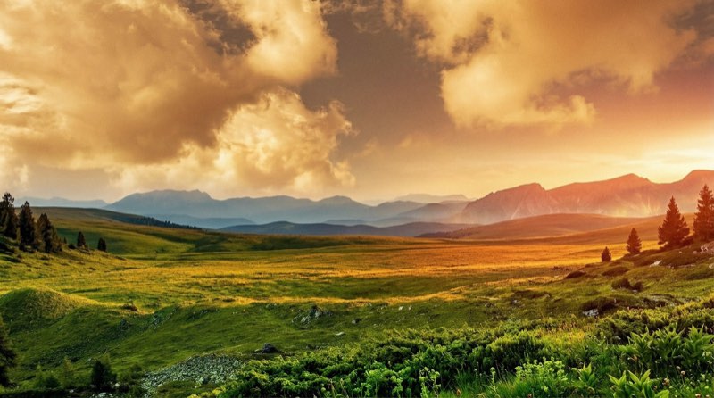 Hochebene im Abendlicht mit Wolkenbank über dem Tal